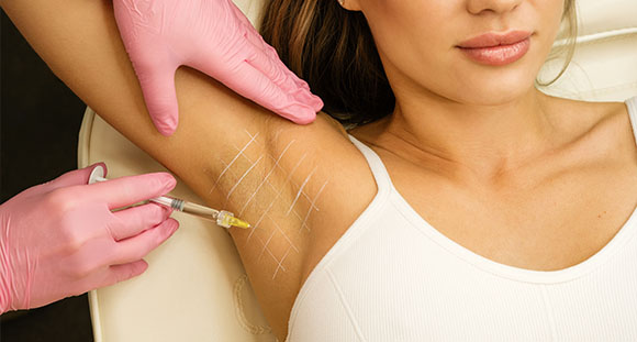 a woman receiving an injection for hyperhidrosis treatments to the underarm
